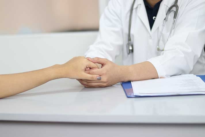 Doctor holding woman's hand